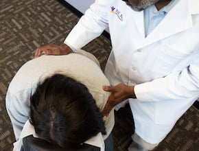 car accident chiropractor helping woman's back