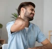 man feeling neck in pain needing whiplash treatment from chiropractor