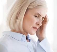 woman having a headache and needing a spice specialist and neurologist